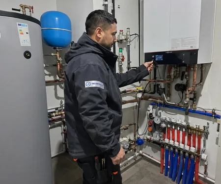 The plumber sets the heating element control panel on the wall next to the boiler tank and the blue expansion tank, the outdoor temperature sensor of the heating element is installed on the north wall of the house where the sun does not shine.