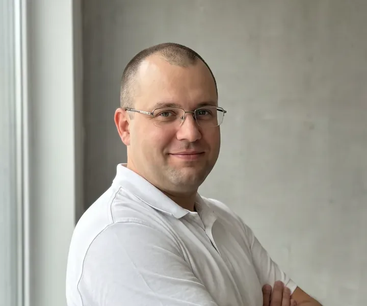 Janek Kruus lühikeseks pügatud juuste, õhukeste metallraamidega prillide ja valge polosärgiga seisab käed rinnal betoonseina ees akna kõrval, uue rikkevoolukaitsme väljalülitusaja mõõdab elektrik testriga millisekundites.